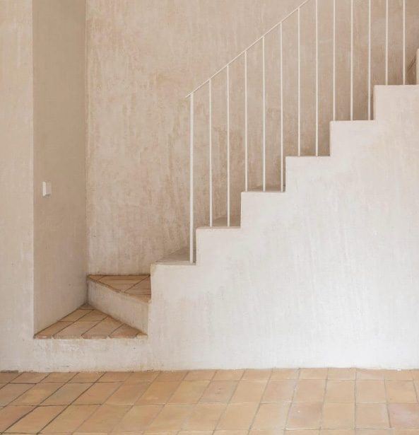 Lime-washed stair with an iron rail